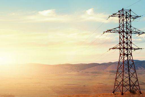 electric-power-pole-in-field-at-sunset