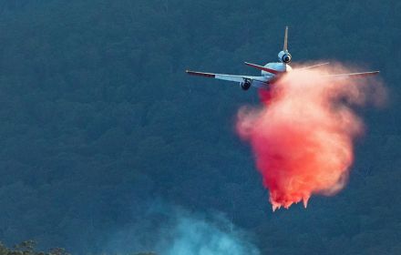 An aircraft waterbombs an out of control bushfire
