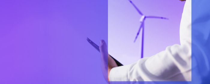 engineer looking at tablet in front of wind turbines