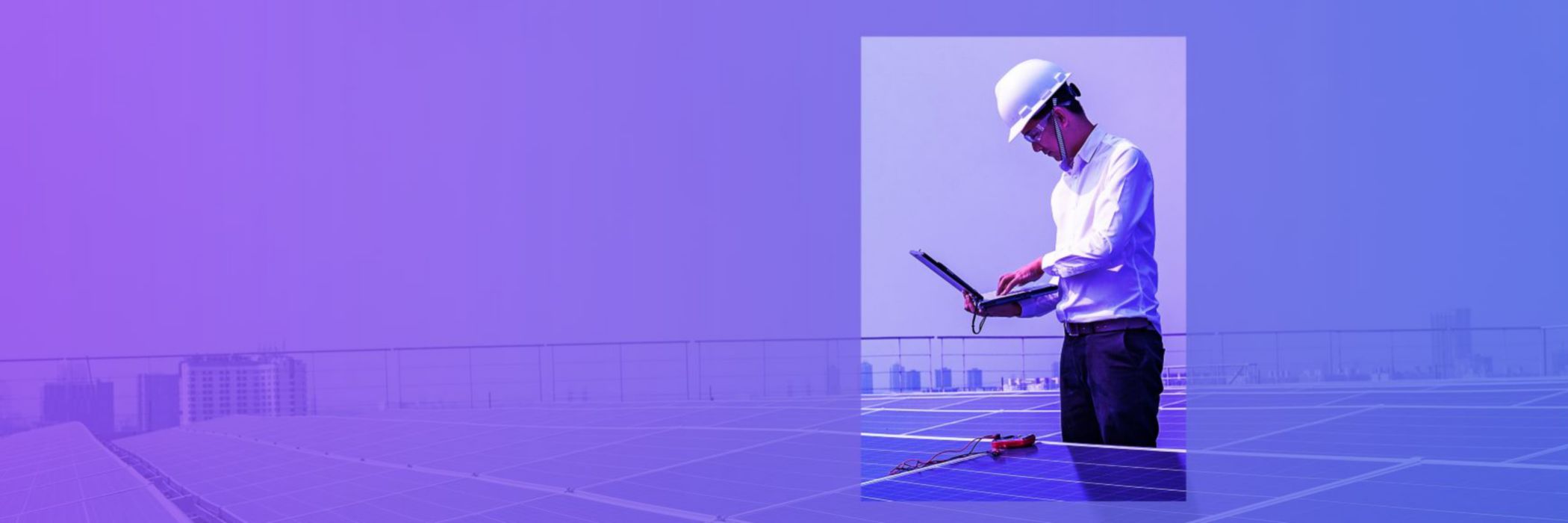 engineer looking on computer in between solar panels