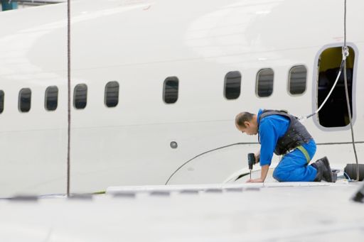 engineer working on wing of passenger jet