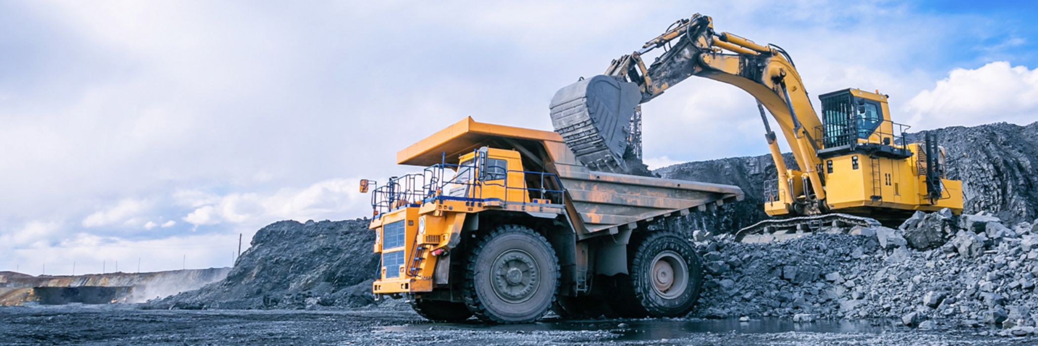 Mining excavator loading rocks in mining truck