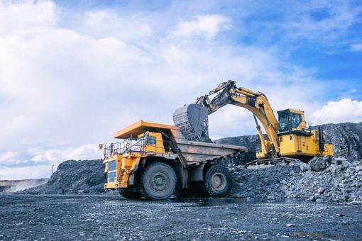 Mining excavator loading rocks in mining truck