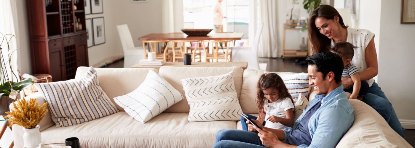 family in living room looking together at tablet