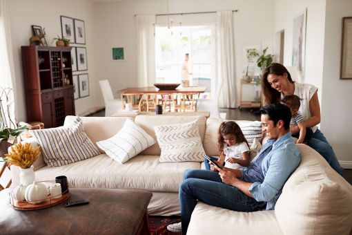 family in living room looking together at tablet