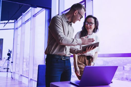 man and woman discussing over laptop