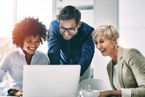 Colleagues looking at screen and smiling