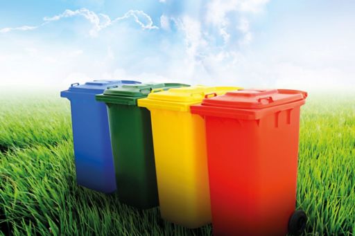 different coloured waste wheelie bins under a blue sky