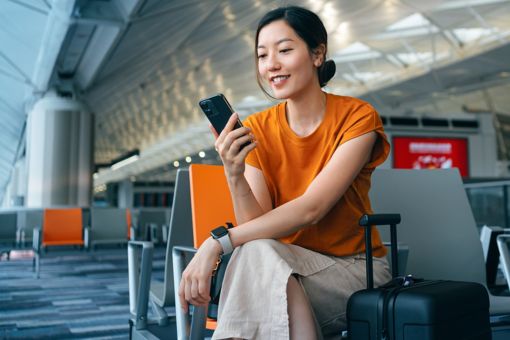 Frau mit Handy am Flughafen