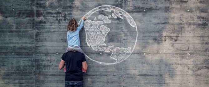 Business case development - Girl drawing earth on wall sitting on father's shoulders
