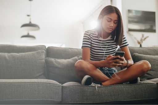 Girl sitting on couch using phone
