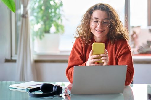 Girl Sitting with phone and laptop