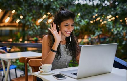 a-girl-smiling-while-working-on-laptop