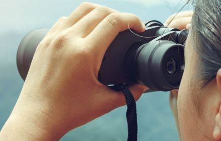 Girl watch hills through binoculars