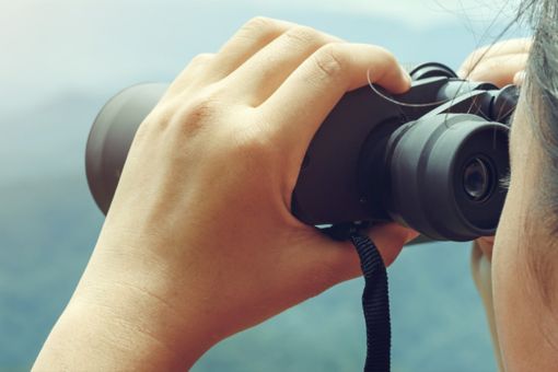 Girl watch hills through binoculars