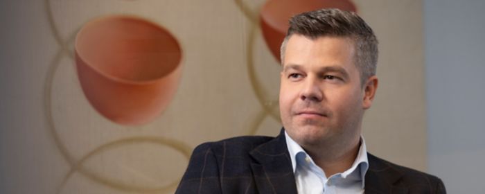 Ungur dökkhærður maður horfir fram fyrir sig á fundi með samstarfsfélögum