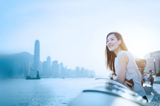 A women looks out at a large city from a viewpoint