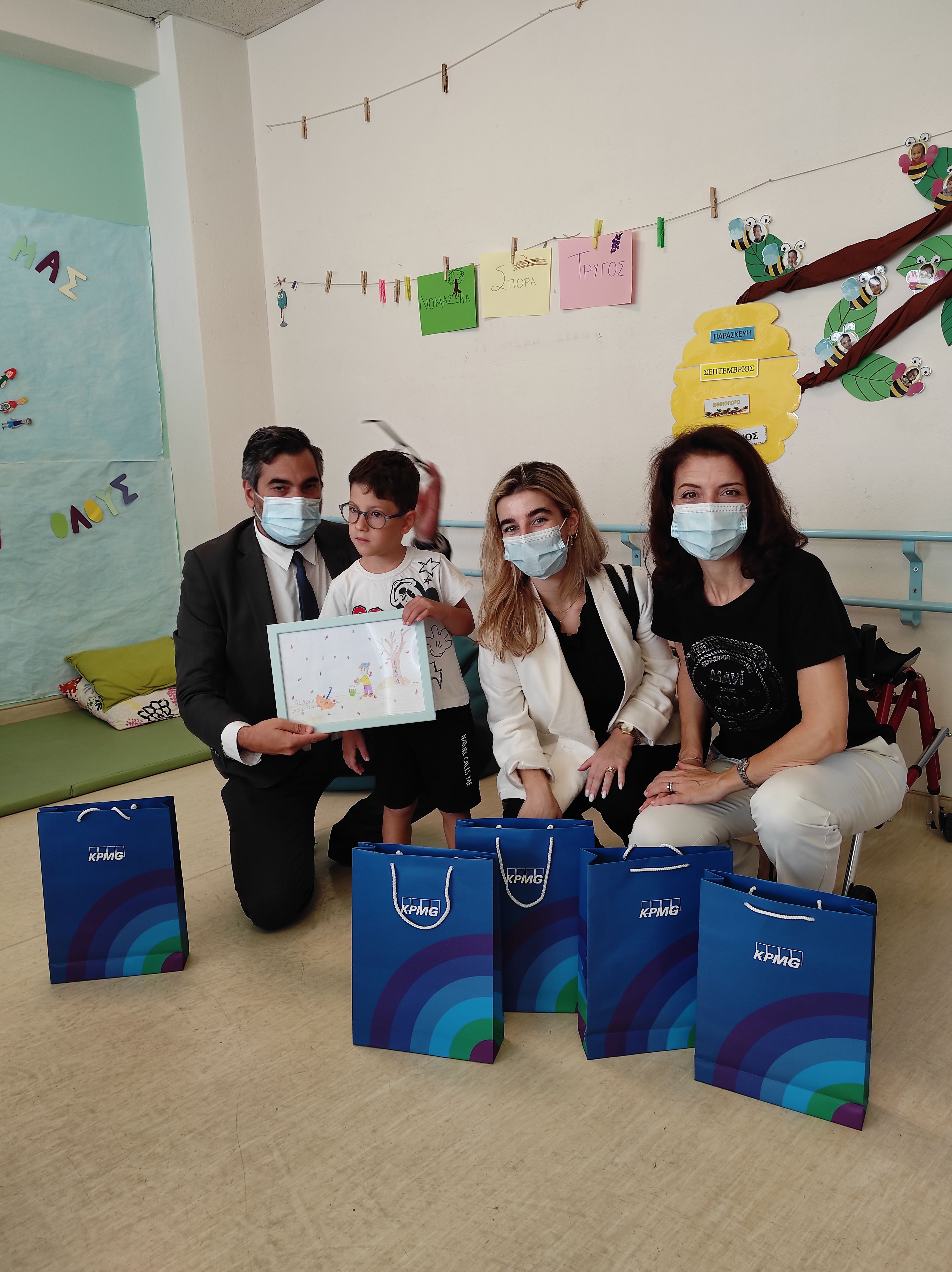 kpmg employees offer books to the children at elepap athens