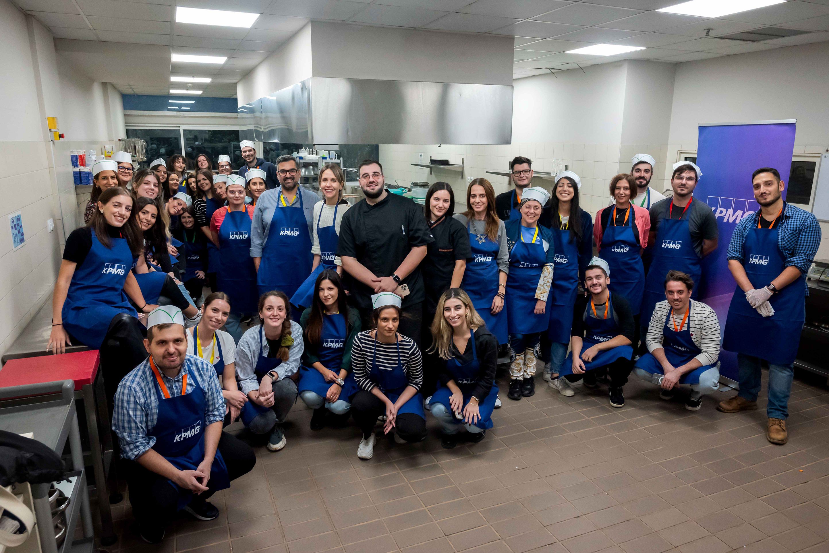 kpmg greece employees participating in cook for good 2023 with stavros varthalitis