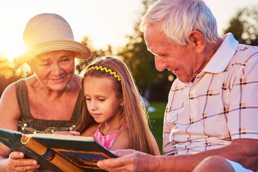 Grands-parents lisant à la petite-fille
