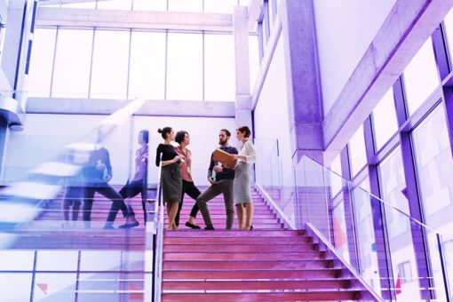 group of people standing on stairs talking