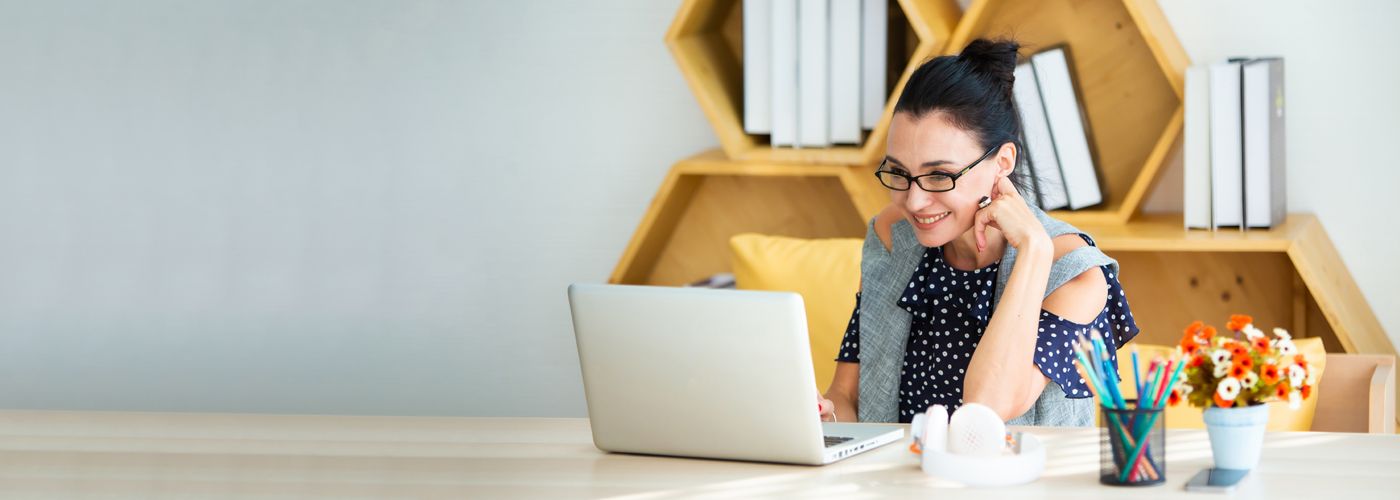 Happy excited successful businesswoman triumphing in modern office with laptop