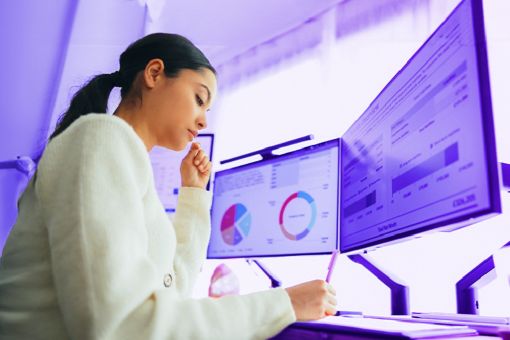 Mujer en la oficina revisando los reportes financieros de manera digital