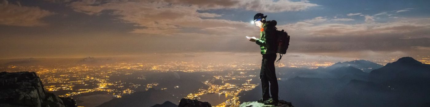 Hiker checking his device on the top of mountain