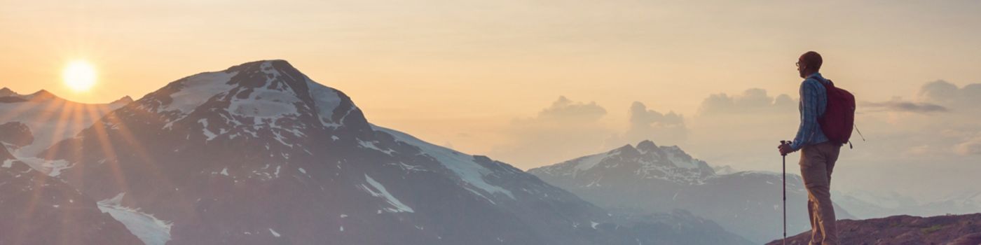 hiker looking over mountains at sunrise