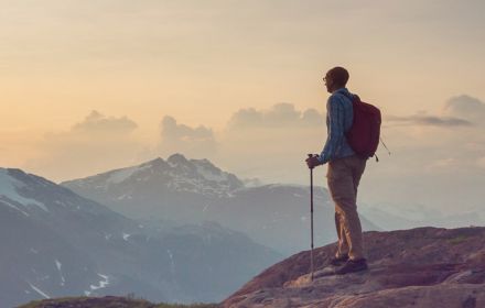 Hiker looking over mountains at sunrise