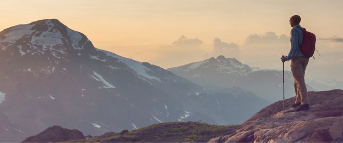 Hiker looking over mountains at sunrise