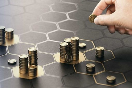 Human hand stacking coins over a black background with hexagonal golden shapes. Concept of investment management and portfolio diversification. Composite image between a hand photography and a 3D back