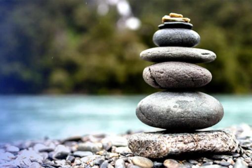 Stacked Rocks in front of Waterfall