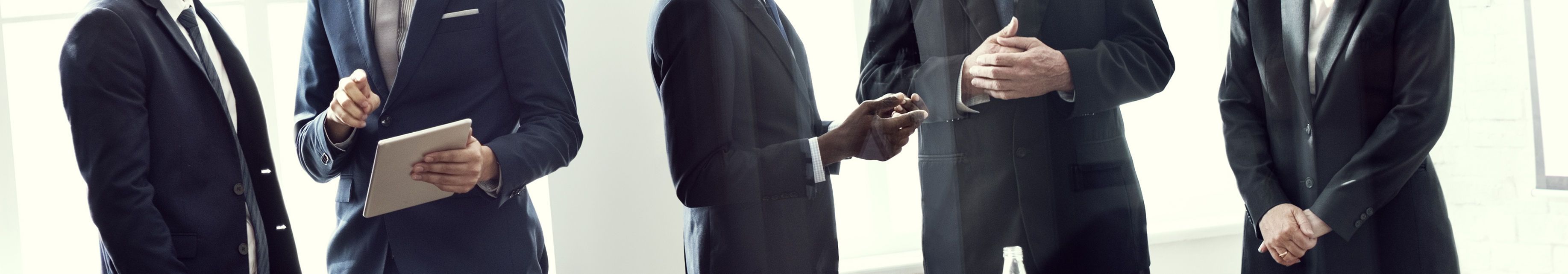 Five people standing in business meeting