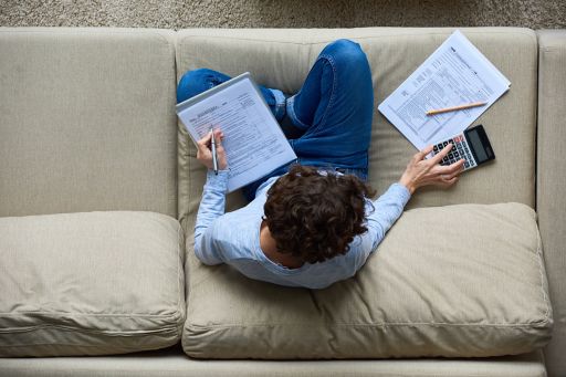 Man sitting on couch making calculations