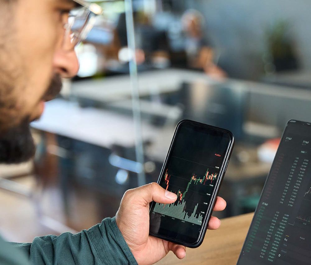 Man holding phone and looking at laptop