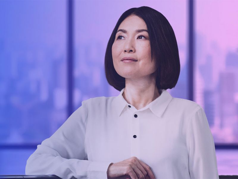 CEO gazing thoughtfully into distance, in office setting