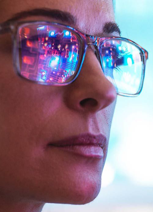 Woman wearing glasses with reflection of computer screen