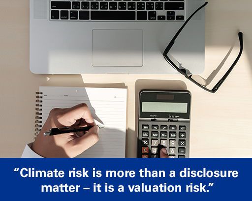 Executive using calculator with text overlaid "Climate risk is more than a disclosure matter – it is a valuation risk."