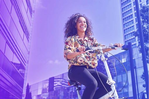 Woman riding bike through city skyscrapers