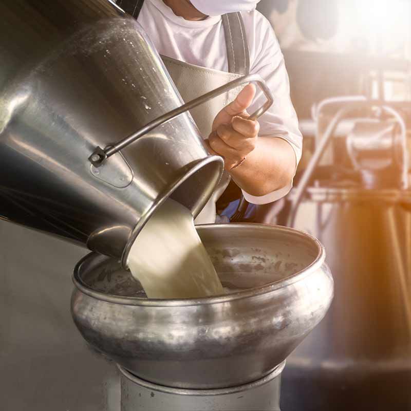 Worker pouring milk