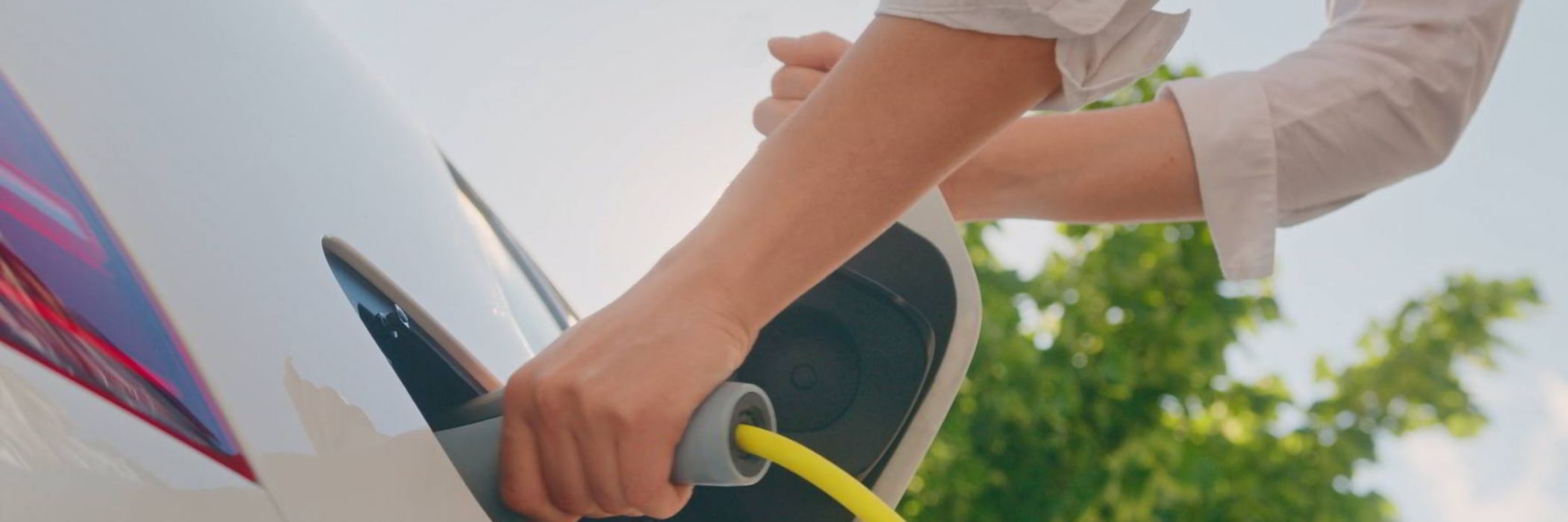 Hand plugging in electric car charger