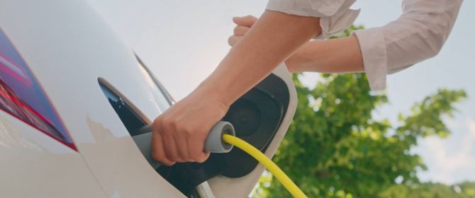 Hand plugging in electric car charger
