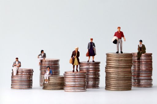 Miniature people sitting on piles of coins