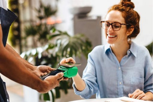 Woman paying in cafe with smartphone