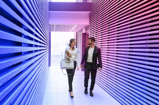 Two colleagues walking in long corridor