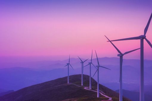 Wind turbines on hill at sunset