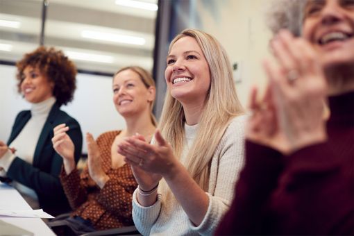 Group of women applauding in office