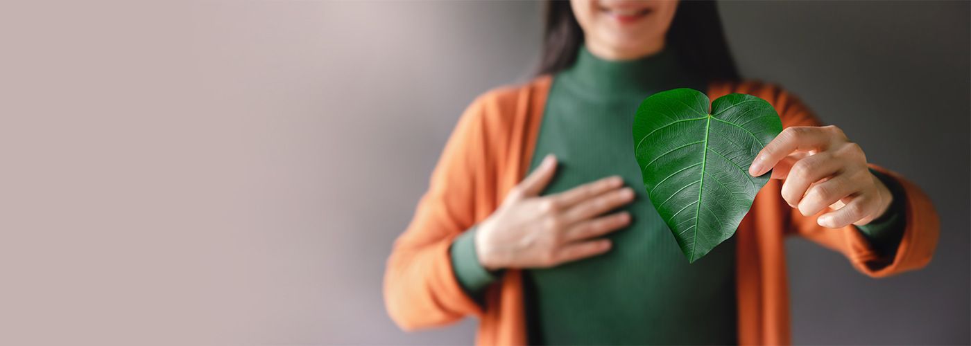 Woman holding leaf in the shape of a heart