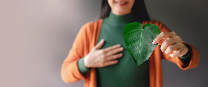 Woman holding leaf in the shape of a heart